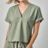 Woman wearing a green outfit with a plain background