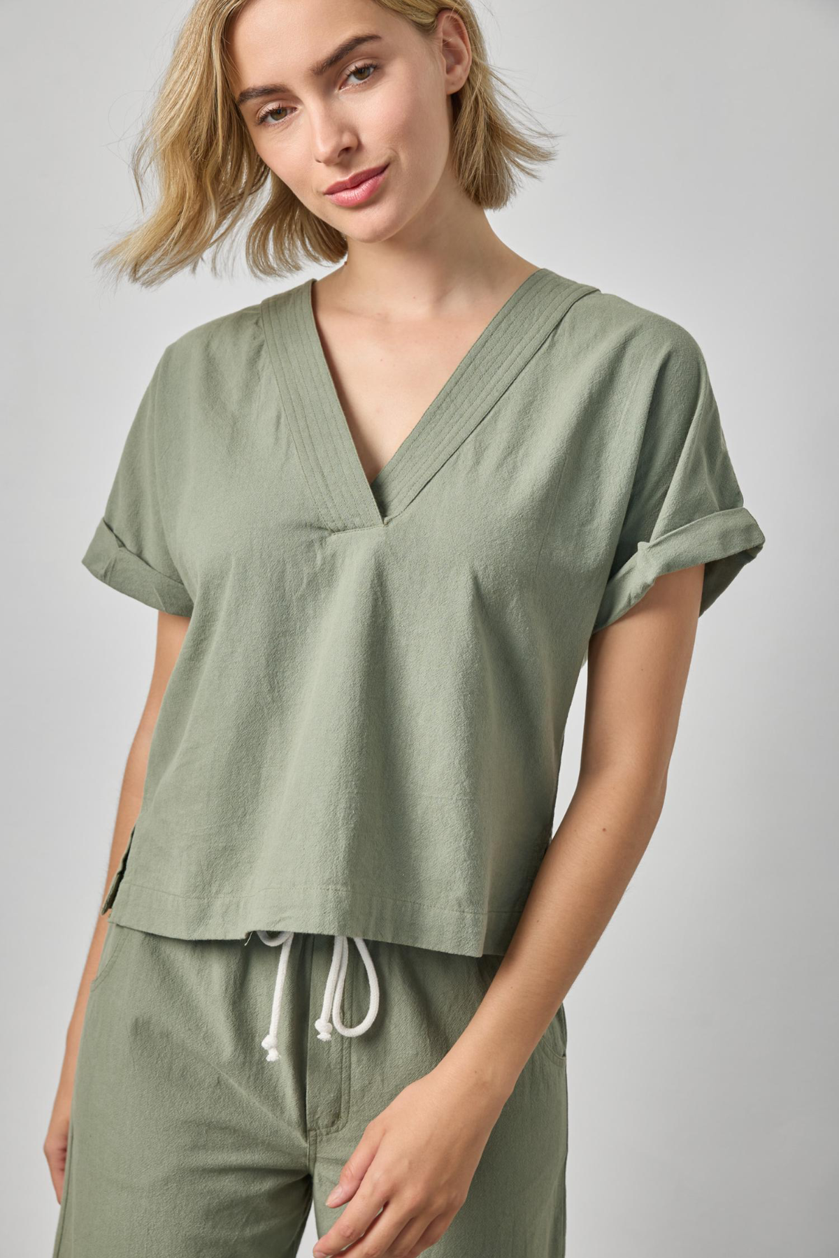 Woman wearing a green outfit with a plain background