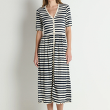 Woman wearing a black and white striped dress against a plain background