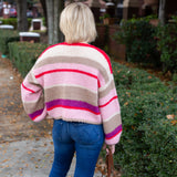 Striped knit cardigan worn open over a simple top