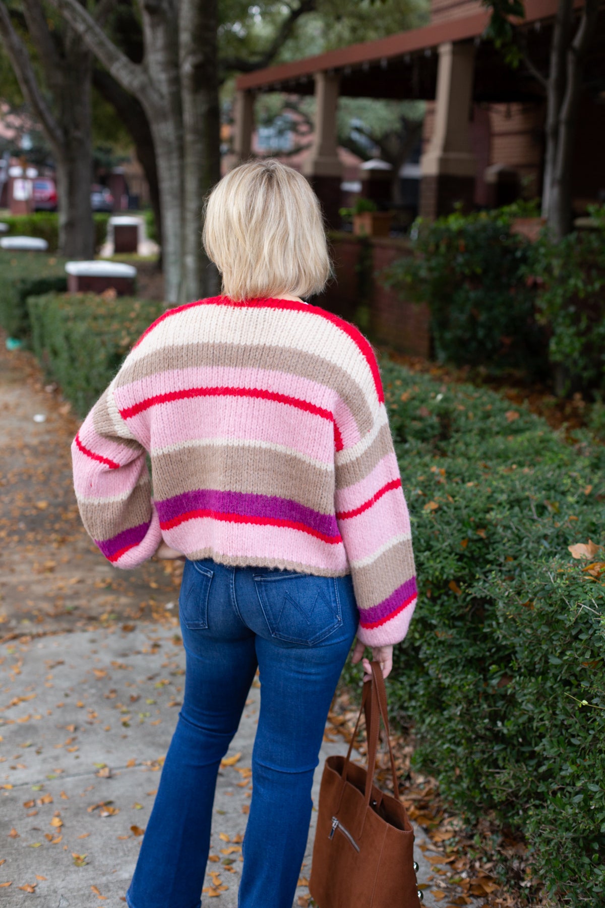 Striped knit cardigan worn open over a simple top