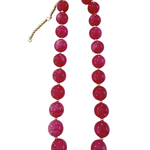 A chunky beaded necklace featuring large, glossy round magenta-pink beads separated by small gold spacer beads, with a gold-tone clasp and extender chain, shown on a plain white background.