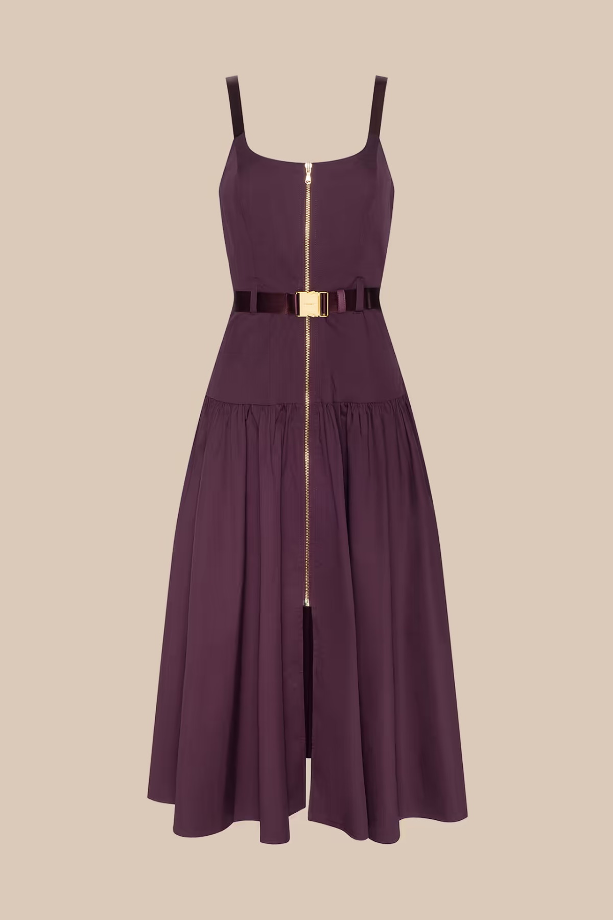 A sleeveless midi dress in deep plum purple with a thin black belt at the waist featuring a gold buckle, and a central gold zipper running down the front. The dress has thin shoulder straps and a tiered skirt, shown against a solid beige background.