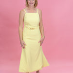 Woman wearing a yellow dress against a pink background