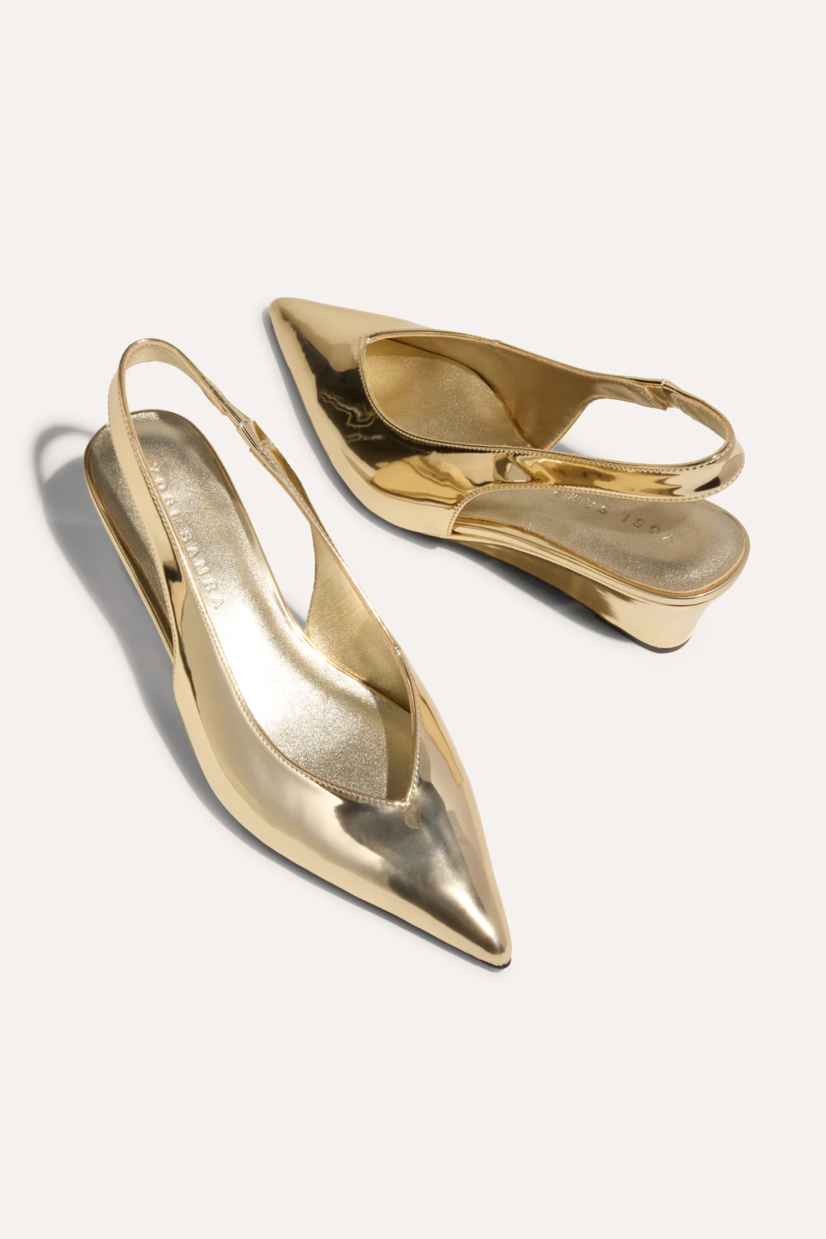 Gold high-heeled shoes on a white background