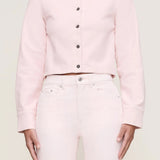 Person wearing a light pink button-up shirt and matching pants on a plain background