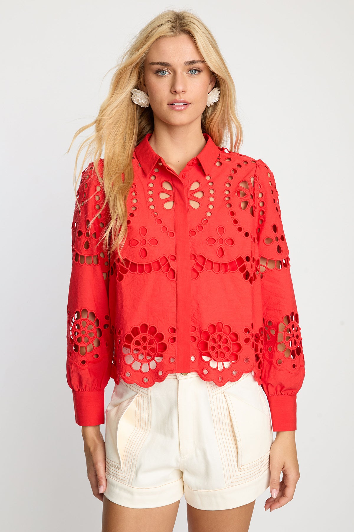 Woman wearing a red lace blouse with a white background