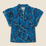 blue floral blouse on tan background 