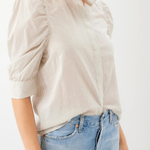 Person wearing a beige striped shirt and blue jeans on a white background
