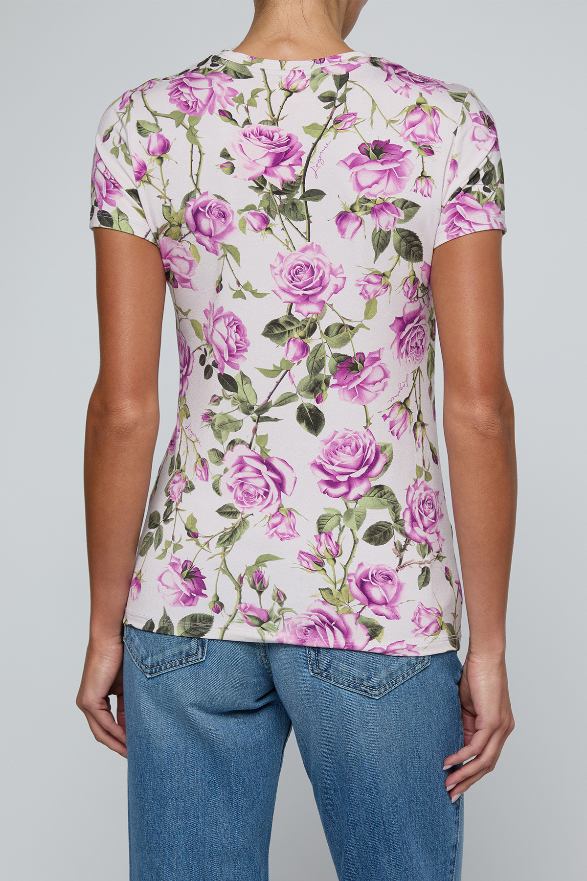 Model wearing rose print tee on a white background.