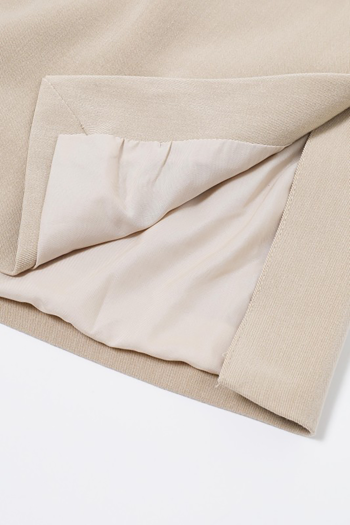 Close-up of beige fabric with a pocket on a white background