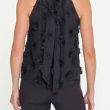 Black halter top with floral details worn by a person on a white background