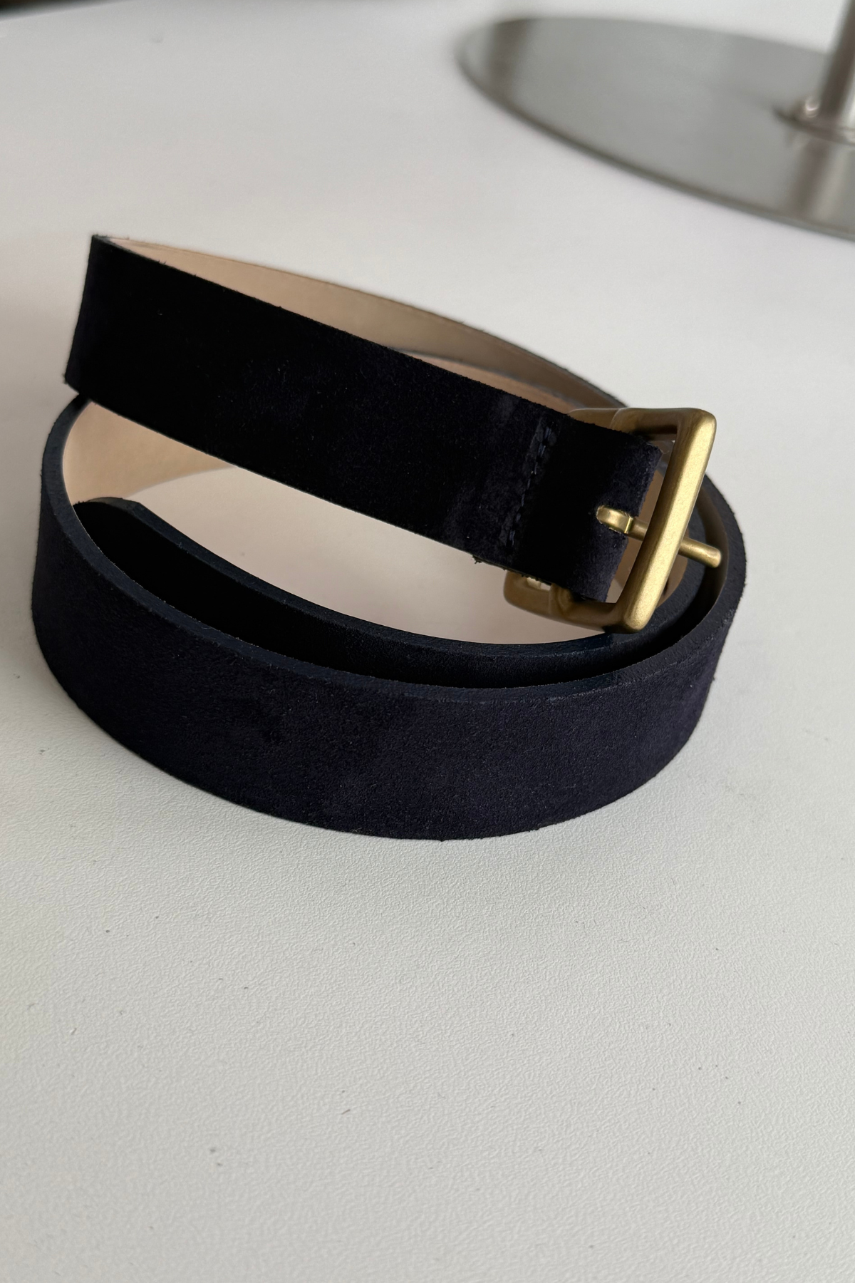 Navy belt with gold buckle on white background