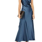 A woman modeling a sleeveless, wrap-style maxi dress in a satin-like blue fabric, holding a dark clutch and wearing black strappy heels against a plain white background.
