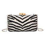 Black and white striped clutch bag with gold chain on a white background