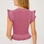 Woman wearing a red and white striped top with ruffled sleeves on a light background