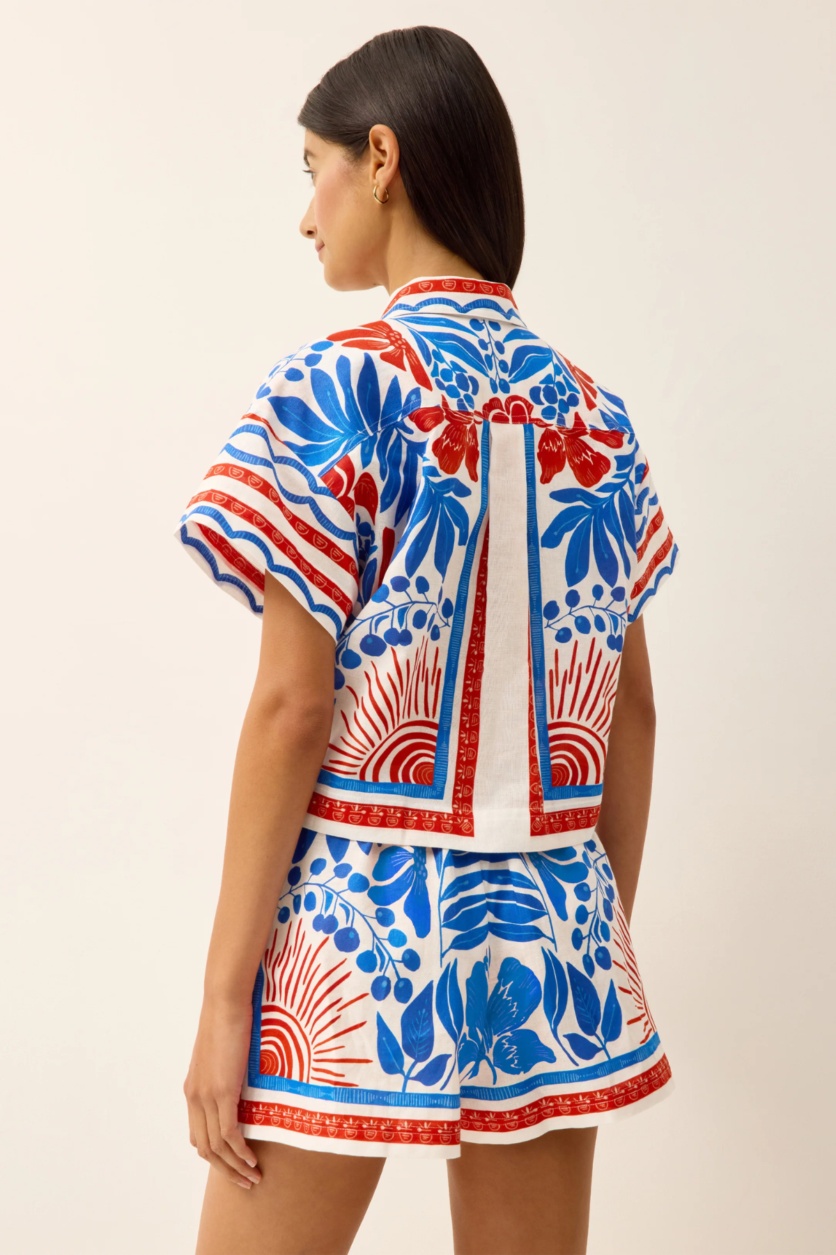 Woman wearing a colorful patterned outfit on a beige background