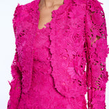 Close-up of a bright pink lace dress with long sleeves on a white background