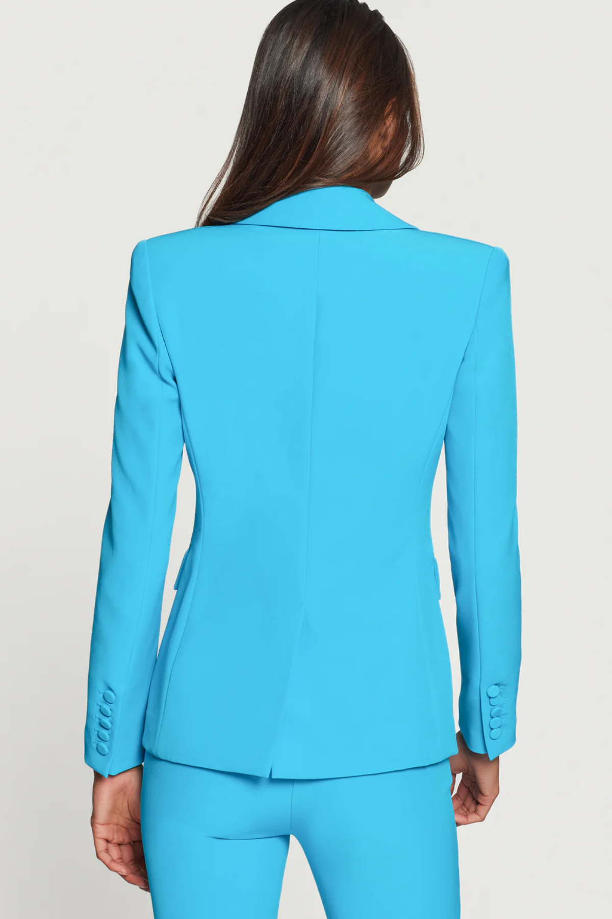 Blue suit jacket worn by a person on a plain background