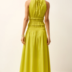 Woman wearing a bright yellow dress against a plain background