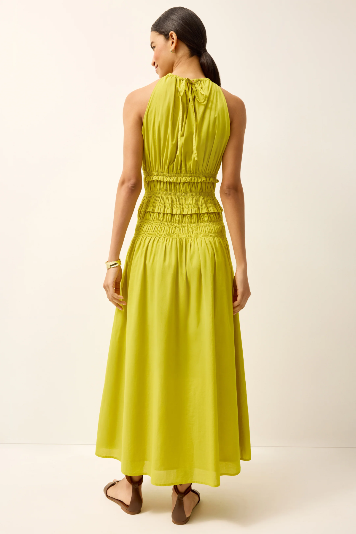 Woman wearing a bright yellow dress against a plain background