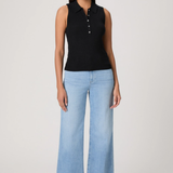 Woman wearing a black sleeveless top and light blue jeans on a white background