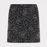 A black A-line mini skirt embellished with a sparkling silver rose pattern, shown flat against a light gray background.