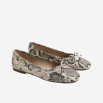 A pair of women's ballet flats featuring a black and beige snakeskin pattern, with small bow details on the toes, shown against a plain light gray background.
