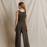 Woman wearing a brown jumpsuit against a plain background