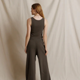 Woman wearing a brown jumpsuit against a plain background