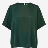 A dark green short-sleeve top with a color-blocked design, featuring a solid dark green upper chest and a slightly lighter forest green lower half, shown against a plain light gray background.