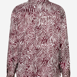 A long-sleeve button-up shirt with a bold zebra-like abstract pattern in deep burgundy and white, shown against a plain light gray background.
