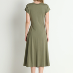 Woman wearing a green dress standing against a white background