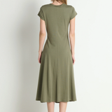 Woman wearing a green dress standing against a white background
