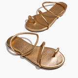 Pair of gold sandals on a white background