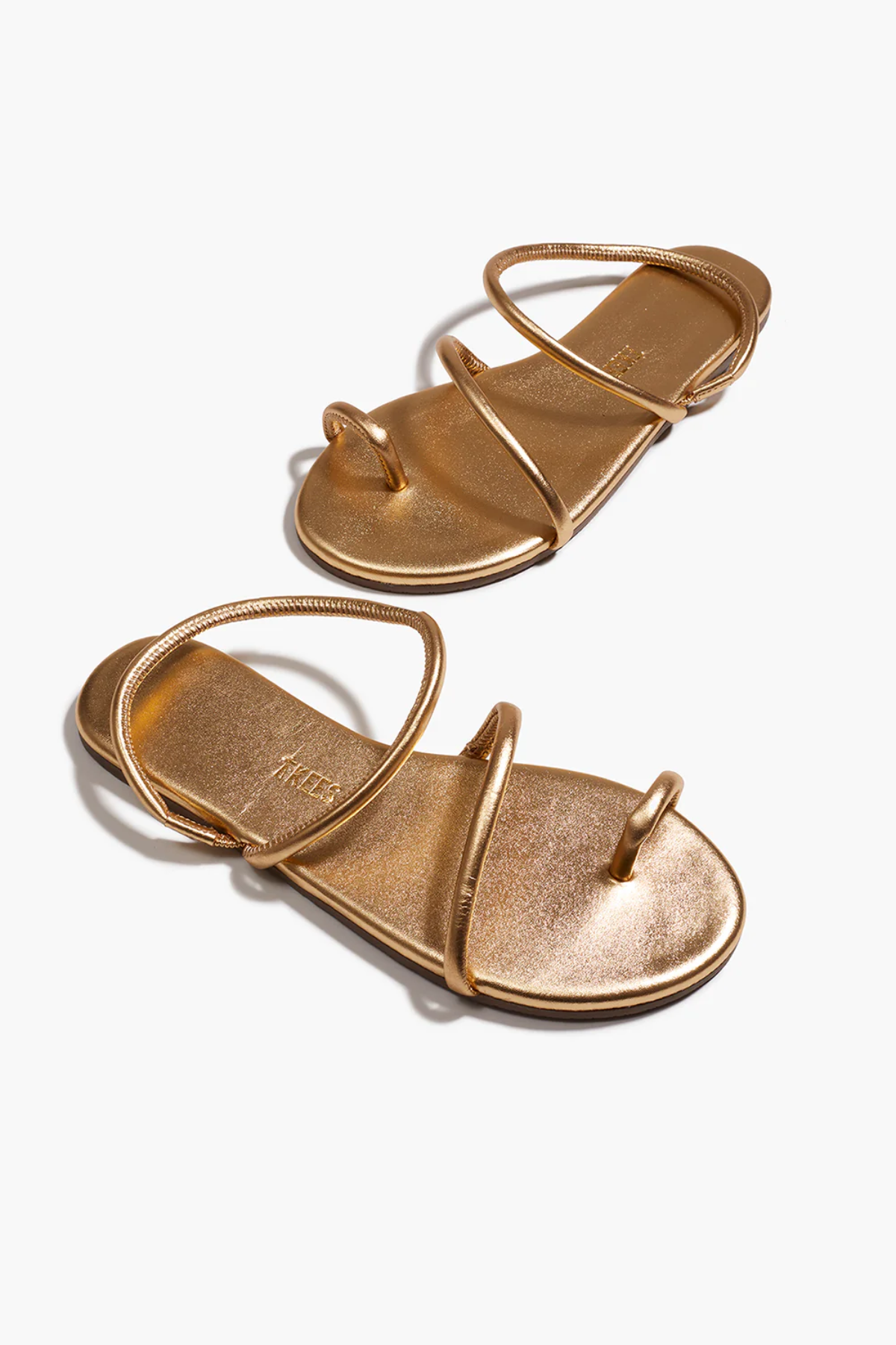 Pair of gold sandals on a white background