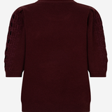 A dark burgundy knit sweater with three-quarter sleeves, featuring textured geometric cutout patterns on the upper sleeves, shown from the back against a light gray background.