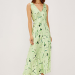 Woman wearing a light green dress with floral pattern on a white background