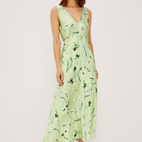 Woman wearing a light green dress with floral pattern on a white background