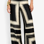 Black and beige striped pants worn by a person on a white background