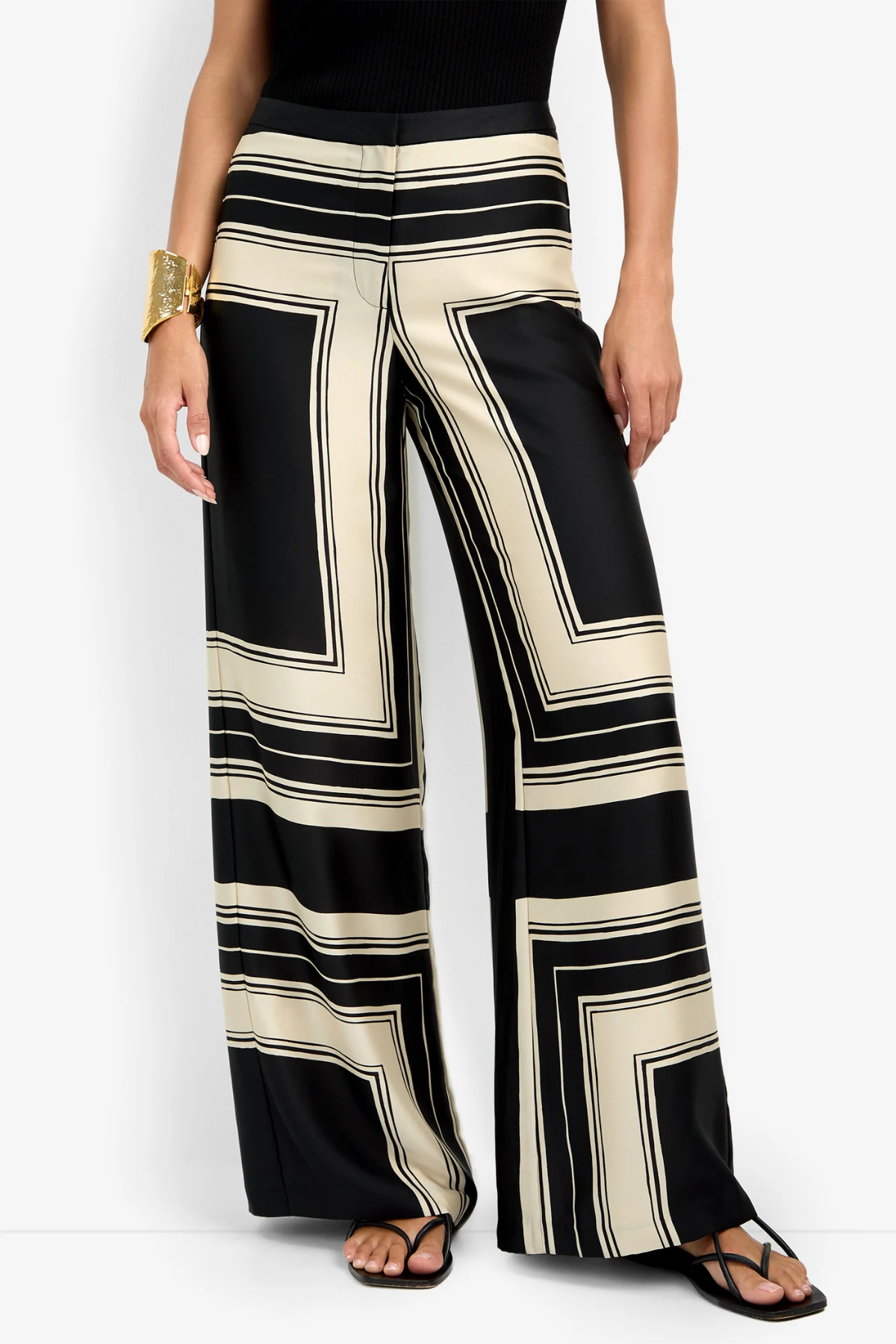 Black and beige striped pants worn by a person on a white background