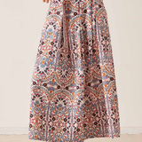 Women's printed midi skirt featuring a flowing silhouette and warm-toned geometric-inspired pattern.