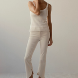 woman in cream outfit and wedges on tan background 