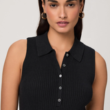 Woman wearing a black sleeveless ribbed top against a plain background