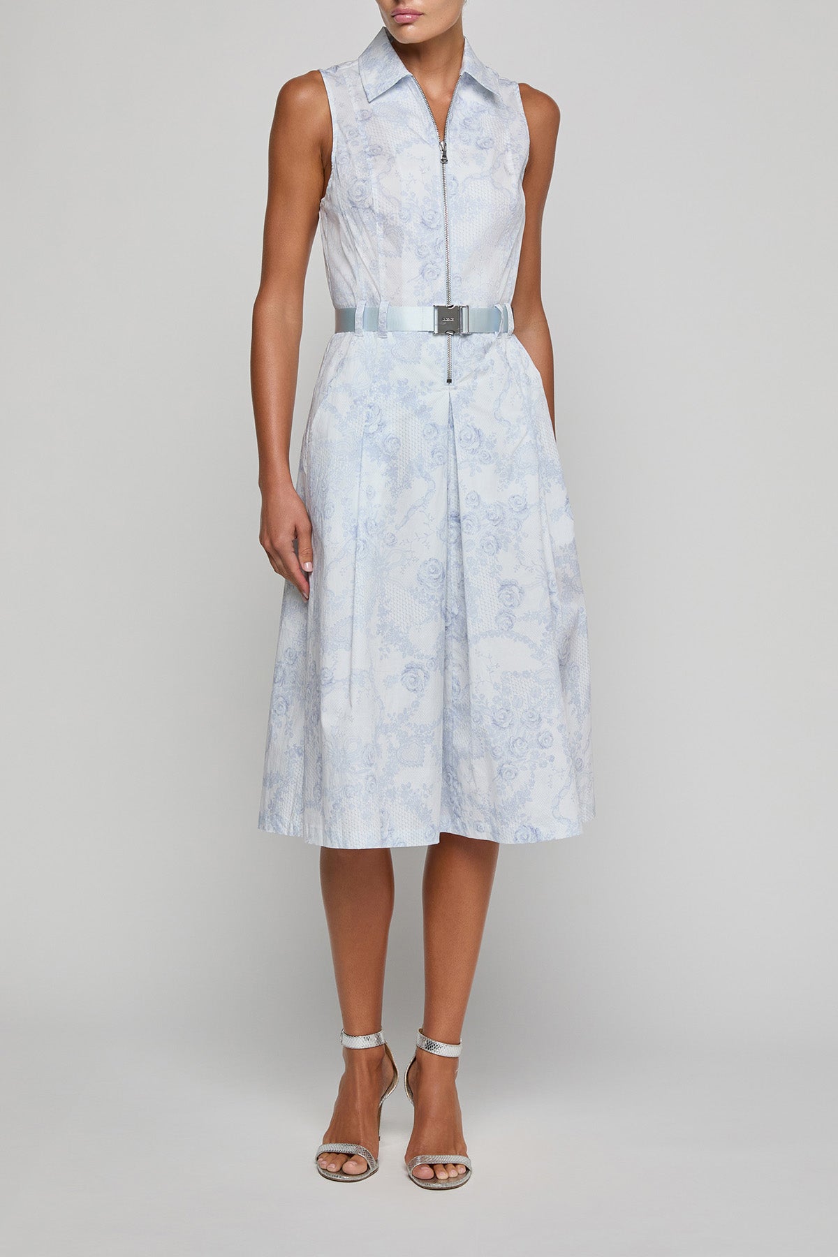 Woman wearing a light blue patterned dress on a plain background