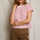 Woman wearing a red and white striped shirt with brown pants against a neutral background