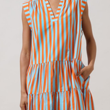 model wearing Sleeveless tiered midi dress featuring vertical orange, blue, and cream stripes with a relaxed, flowing silhouette.