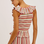 Woman wearing a striped sleeveless top with ruffled details on a white background