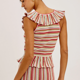 Woman wearing a striped sleeveless top with ruffled details on a white background