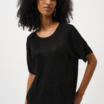 Woman wearing a black textured top against a white background